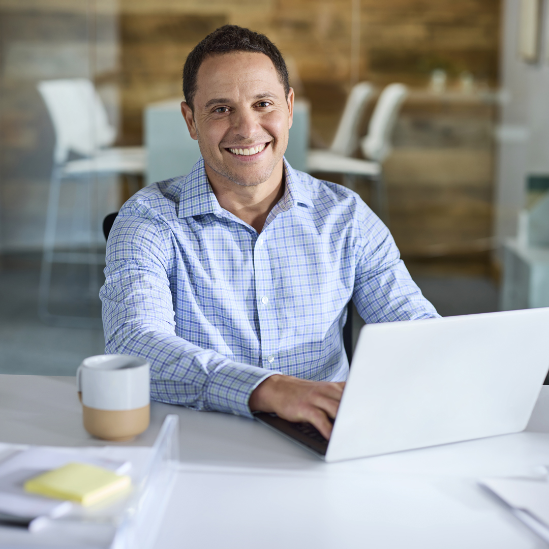 Man working on laptop with coffee.